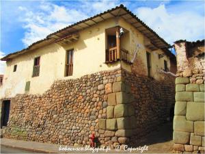 a stone building with a balcony on a stone wall at Cori Wasi in Cusco