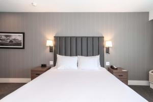 サスカトゥーンにあるSandman Signature Saskatoon South Hotelの白いシーツと枕が付いた大きなベッドのある寝室 +60枚の写真