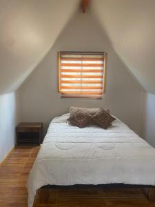a bedroom with a white bed with a window at Escapada romántica de día con tinaja caliente opcional in Pirque