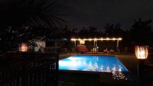 a swimming pool at night with lights on it at Escapada romántica de día con tinaja caliente opcional in Pirque