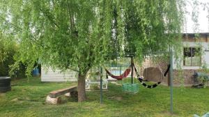 a hammock under a tree in a yard at Escapada romántica de día con tinaja caliente opcional in Pirque