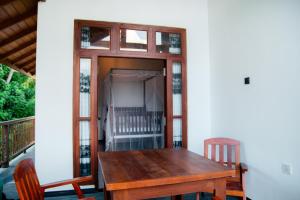 a wooden table and chairs sitting on a porch at River Relax Villa in Ahangama