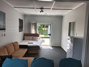 a living room with a couch and a bed at 5 Bedroom House, 7 Salisbury Road, Rotorua in Rotorua