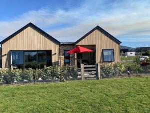 a house with a red umbrella in front of it at Alpine Abode in Wanaka