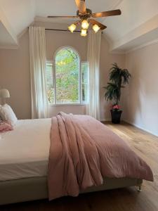 una camera da letto con un letto con un ventilatore a soffitto e una finestra di Vero Villa Golf&Relax a Douglasville
