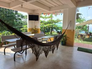 ノカイマにあるPioneros Campestreの椅子とテーブル付きの客室内のハンモック