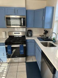 a kitchen with blue cabinets and a stove and a sink at Genevieves lovely suite in Jersey City +14 photos