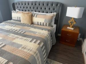 a bedroom with a bed and a lamp on a night stand at Genevieves lovely suite in Jersey City