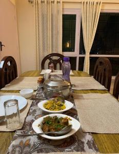 a table with plates of food on top of it at Kainchi Premium Homestay 4BHk in Bhowāli