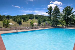 Una gran piscina azul con una mesa y sillas. en Liberty Mountain Resort, en Fairfield