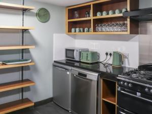 eine Küche mit Herd und Mikrowelle in der Unterkunft Rhiw Farmhouse in Llangelynin + 14 Fotos