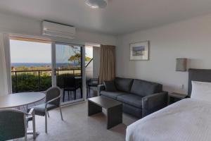 a hotel room with a bed and a couch and a table at Amooran Oceanside Apartments and Motel in Narooma +88 photos