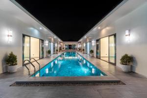 einen Pool in einem Gebäude mit Fenstern in der Unterkunft T M L-Manor House 6 bedroom-independent swimming pool and powerful KTV in Ban Huai Yai