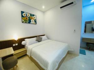 ヌサドゥアにあるAdhya villaの白いベッドルーム(ベッド1台、デスク、写真付)