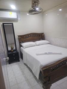 une chambre avec un grand lit et un miroir dans l'établissement Hotel Calderon, à Valledupar