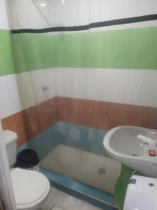 une salle de bains avec toilettes, baignoire et lavabo dans l'établissement Hotel Calderon, à Valledupar 8 autres photos