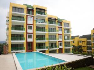 a large apartment building with a swimming pool in front of it at Kudrats Nook -Seaview Bohemian Studio in Canacona