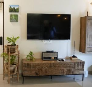 a living room with a large television on a wall at Kudrats Nook -Seaview Bohemian Studio in Canacona