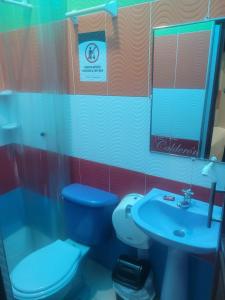une salle de bain avec des toilettes bleues et un lavabo dans l'établissement Hotel Calderon, à Valledupar