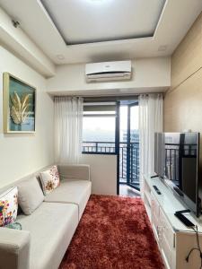 a living room with a couch and a television at Beauty Cindrella Home Makati Penthouse 3 Bedroom in Manila