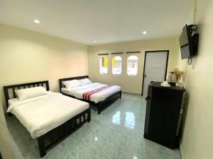 a bedroom with two beds and a television in it at Sleep At Home - Don Mueang in Ban Ko