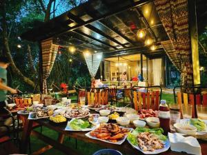 a table with many plates of food on it at La Vie En Rose Ba Vì Homestay in Hanoi