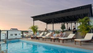 a group of people sitting on lounge chairs next to a swimming pool at Onederz Siem Reap in Siem Reap