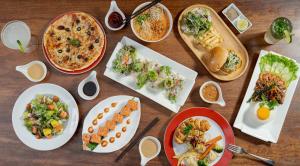 a wooden table with plates of food on it at Onederz Siem Reap in Siem Reap