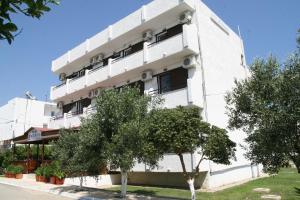 a white building with trees in front of it at Andavis Hotel in Kardamaina +16 photos
