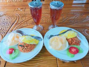 two plates of food and two drinks on a table at pinggan box glamping in Bangli
