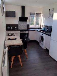 a kitchen with a table and chairs in a kitchen at Le 4G Home Plain-pied #2Chb-3lits #Jacuzzi #Parking Securisé in Crépand