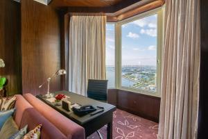 a room with a pink couch and a large window at Diamond Hotel Philippines in Manila