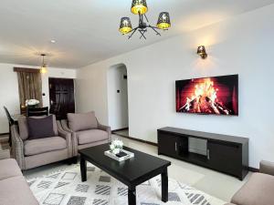 ナクルにあるMilimani Executive Suites With Pool, GYM, Secure Parkingのリビングルーム(壁に暖炉付)