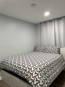 a bed in a bedroom with a white wall at Yellowknife Down Town Retreat in Yellowknife