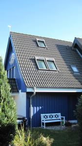 a blue house with a bench in front of it at Ferienwohnungen Reetwinkel in Wieck in Wieck