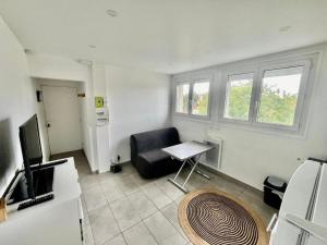 a living room with a black chair and a television at Le canoe in Vaires-sur-Marne