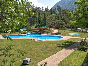 une grande piscine dans un parc arboré dans l'établissement Hotel Grüsch, à Grüsch