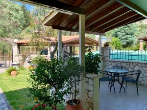 a patio with a table and chairs and a fence at Alkionis Garden View Apartments in Lefkada