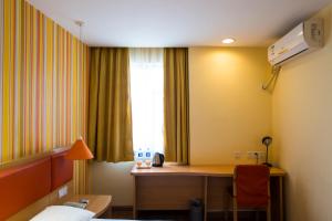 
a room with a desk, chair and a lamp at Home Inn Beijing Capital Airport in Shunyi

