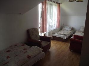 イステブナにあるDomek u Janaのベッド1台、椅子、窓が備わる客室です。