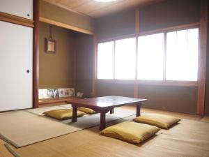 ein Esszimmer mit einem Tisch und zwei Kissen in der Unterkunft ICHIE Second Location in Tanabe