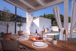 a wooden table with a bowl of fruit and a bottle of wine at Casa Rustivéra - Island Hvar in Vrbanj