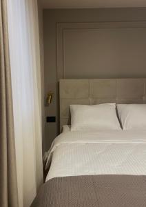 un letto con lenzuola e cuscini bianchi in una camera da letto di City Center Novi Sad #9 a Novi Sad