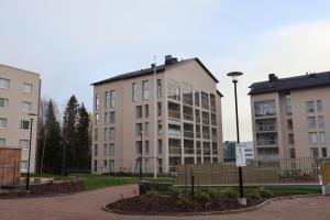 a group of buildings in a park with a street light at Modern 2-Bedroom Apartment with Sauna, Forest View & Parking in Espoo