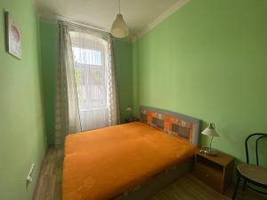 una habitación con una cama naranja en una habitación verde en Apartments Zahradní, en Karlovy Vary