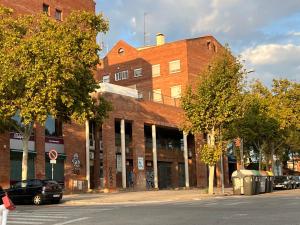 サバデイにあるTessasapartments Sabadellの正面に車を停めた通りのレンガ造りの建物