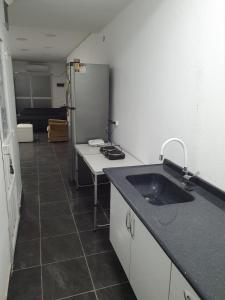 una cocina con fregadero y refrigerador en Glam, en Santiago del Estero