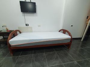 Cama en habitación con TV en la pared en Glam, en Santiago del Estero