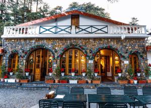 a stone building with benches in front of it at Devdar Woods - An LVB Experience in Dehradun