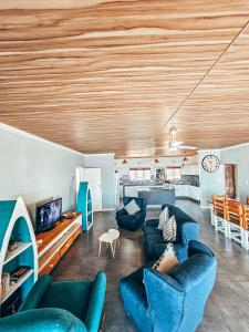un soggiorno con divani blu e una cucina di Southport Coral a Southport Altre 21 foto